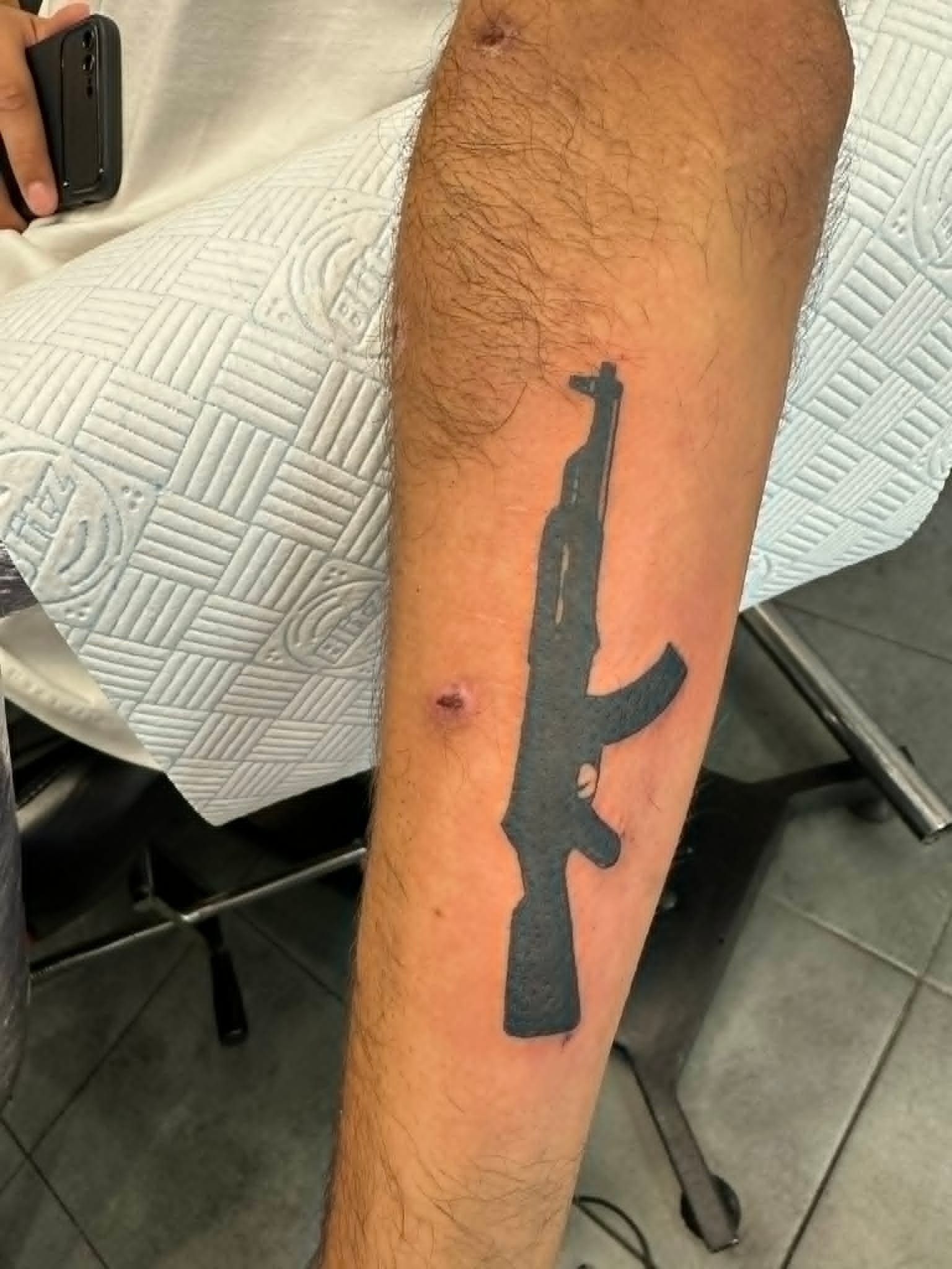 Custom AK47 rifle silhouette tattoo on the forearm by John Quinn at Tattoo Zone, tattoos Newcastle.