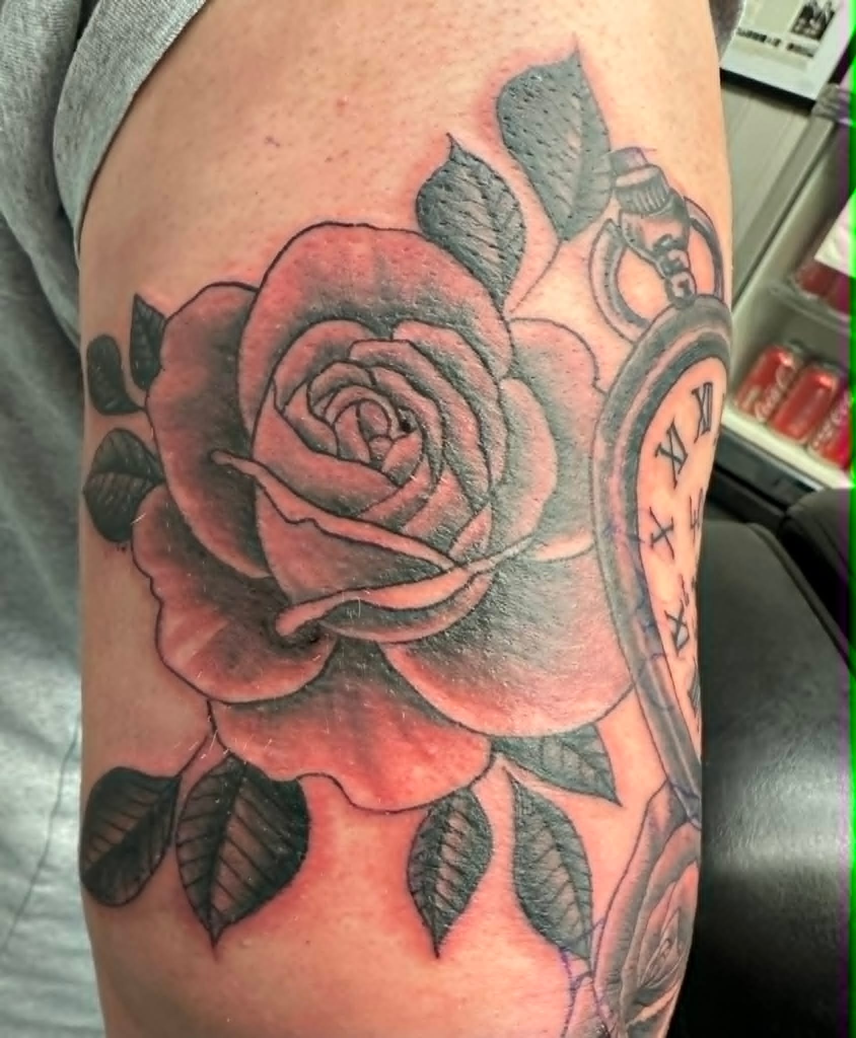 Black and grey rose with pocket watch tattoo on the upper arm by John Quinn at Tattoo Zone Newcastle.