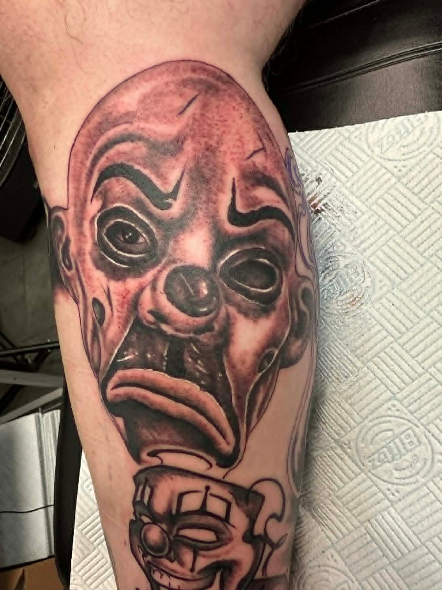 Black and grey chicano clown faces on calf by John Quinn at Tattoo Zone, tattoos Newcastle.