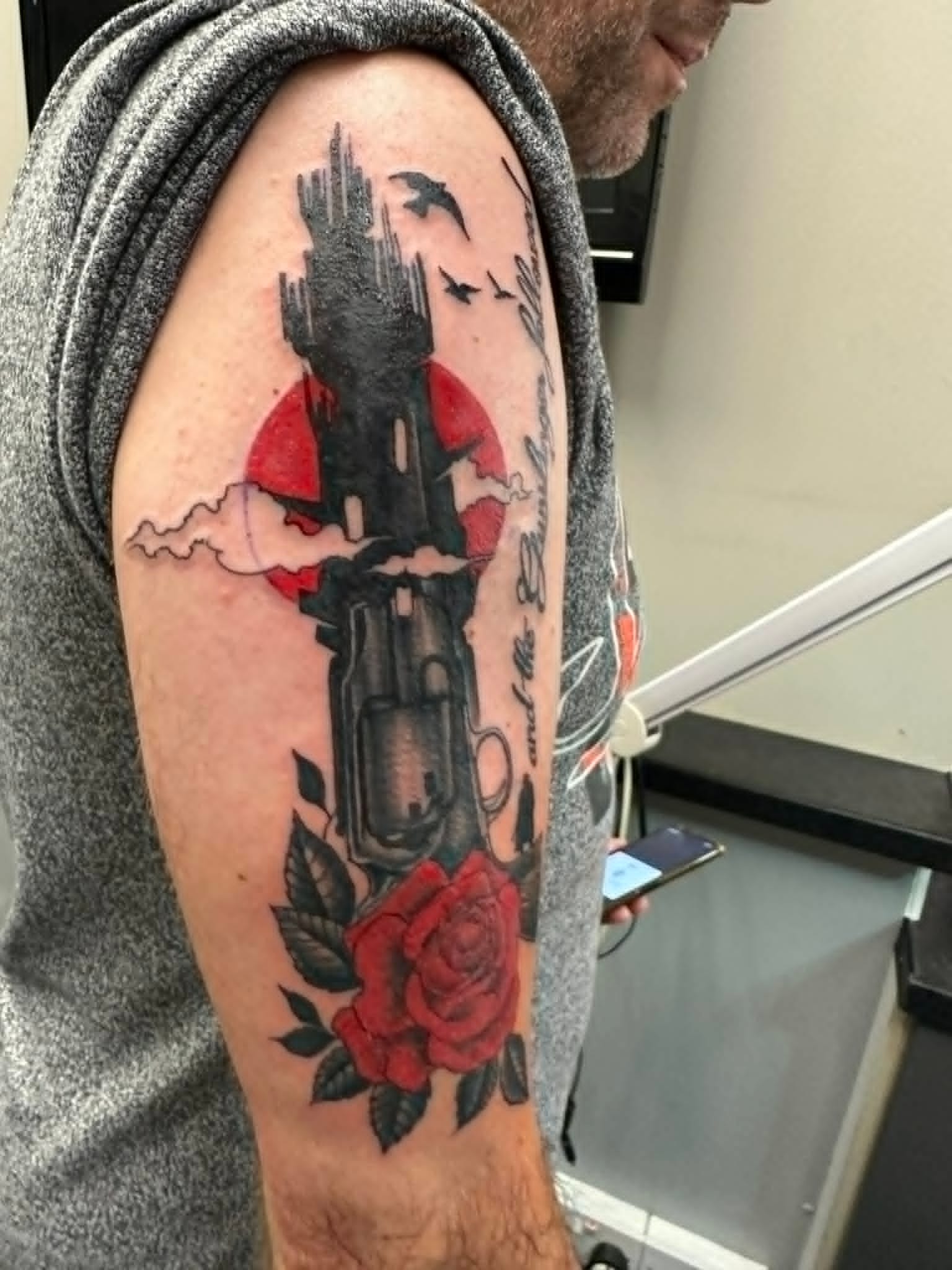 Custom Dark Tower revolver and red rose arm tattoo by John Quinn at Tattoo Zone, tattoos Newcastle.