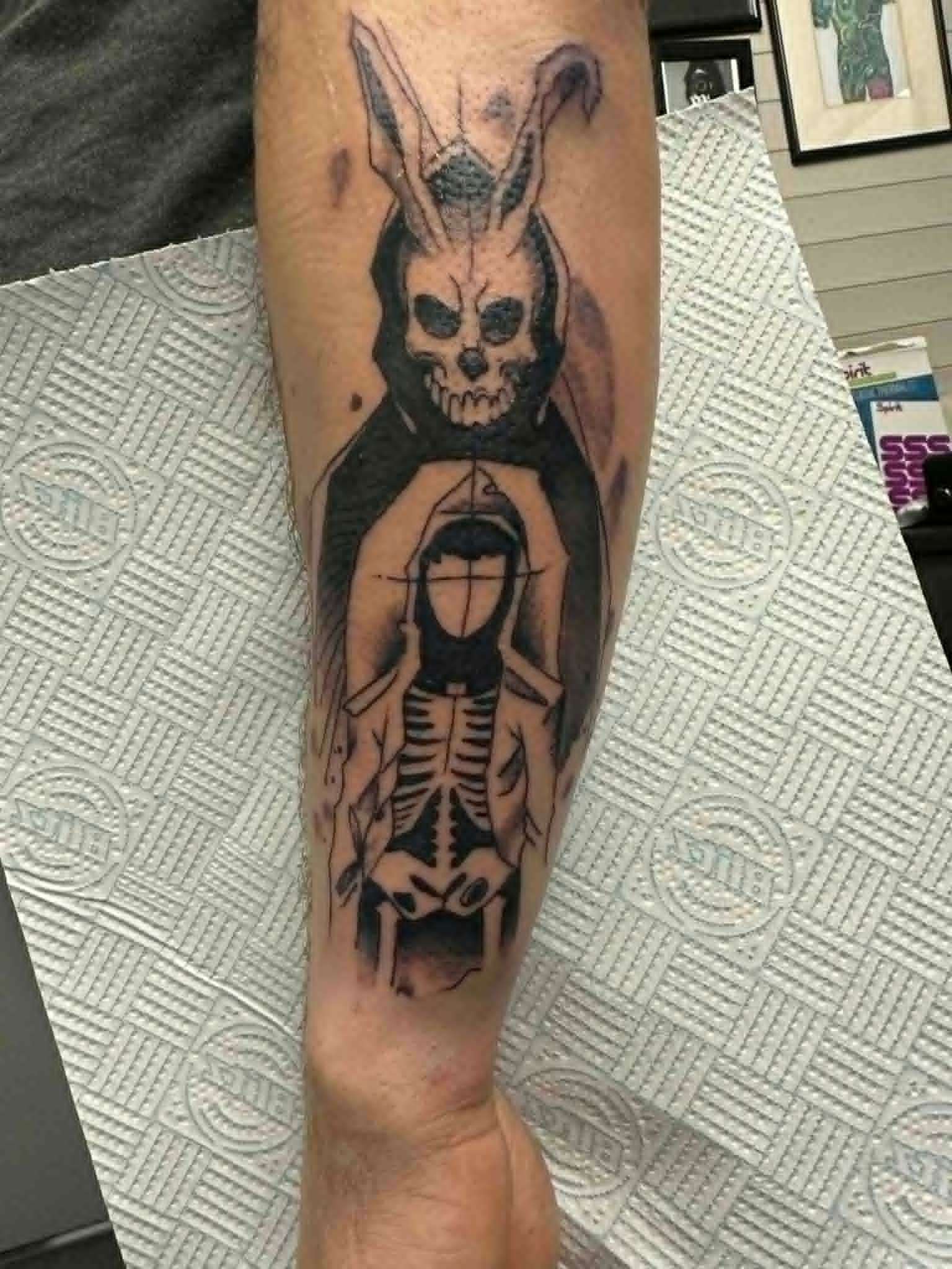 Custom Donnie Darko Frank rabbit mask above hooded skeleton girl forearm tattoo by John Quinn at Tattoo Zone Newcastle.