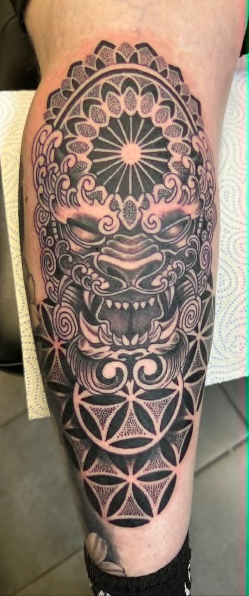 Black and grey foo dog with mandala and flower of life on calf by John Quinn at Tattoo Zone, tattoos Newcastle.