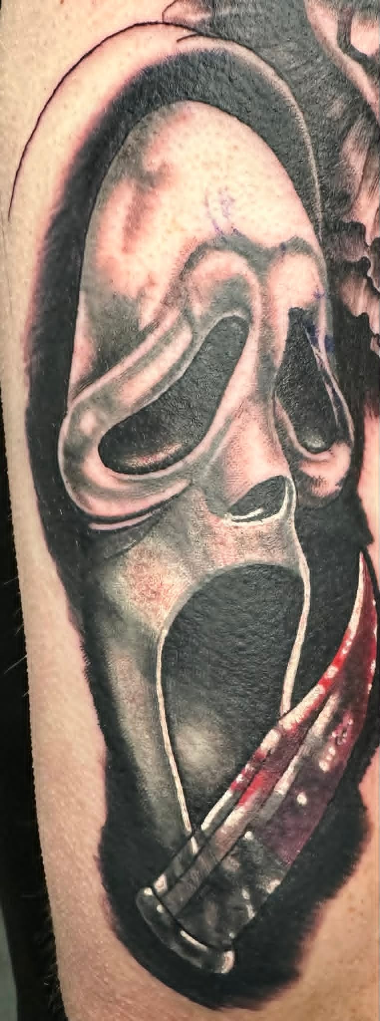Black and grey realism Ghostface mask with bloody knife arm tattoo by John Quinn at Tattoo Zone, tattoos Newcastle.