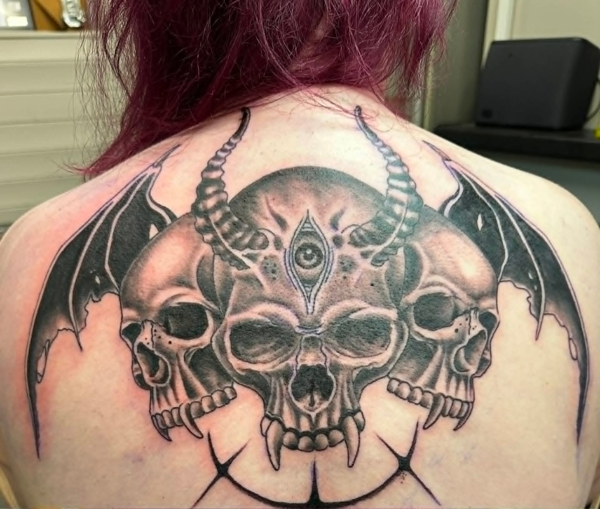 Black and grey horned skulls with bat wings back tattoo by John Quinn at Tattoo Zone, tattoos Newcastle.