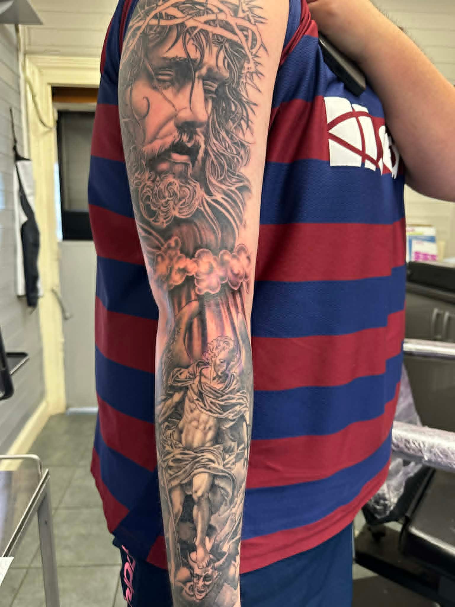 Black and grey realism Jesus and religious figure sleeve tattoo by John Quinn at Tattoo Zone, tattoos Newcastle.