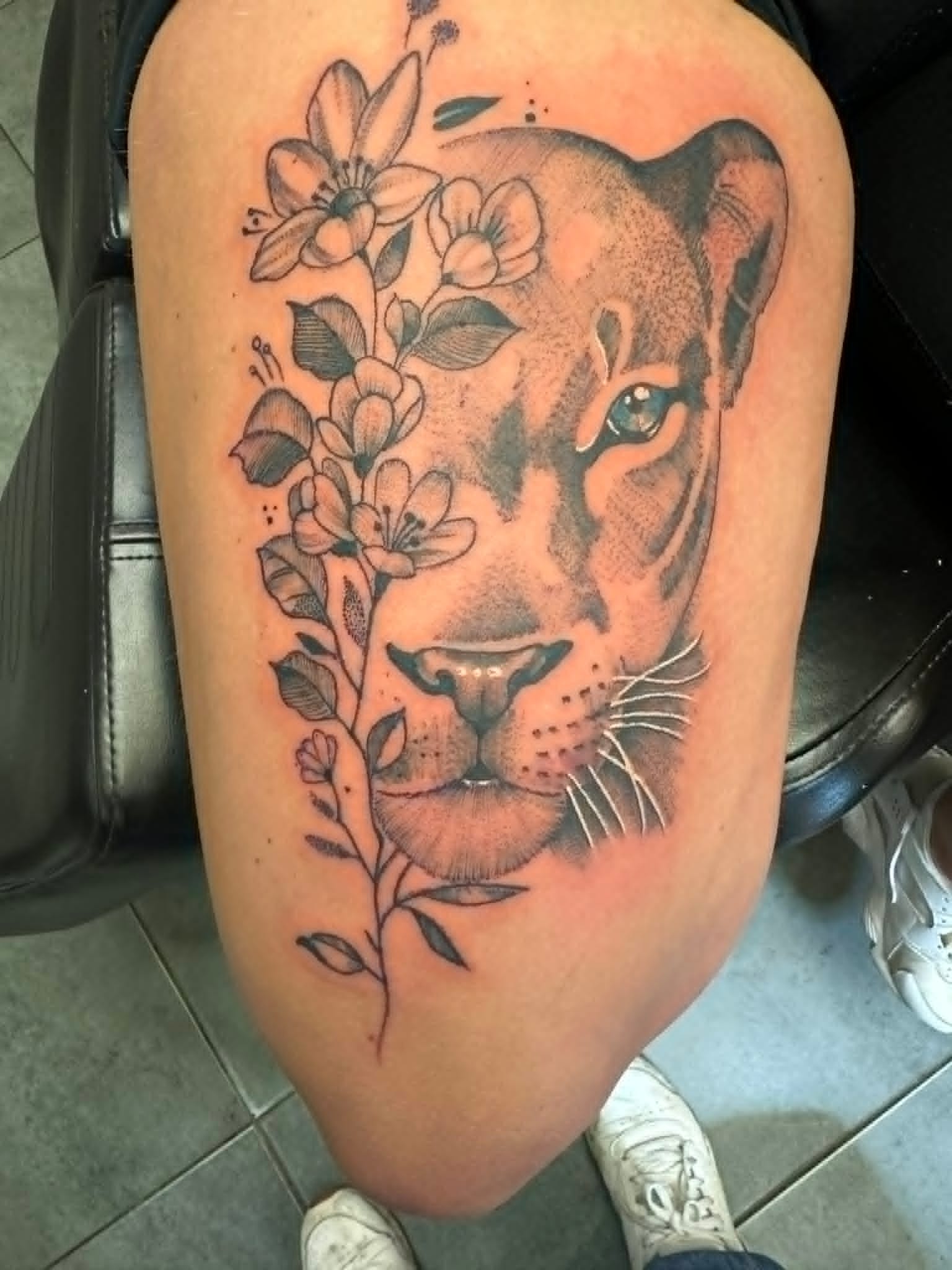 Fine line lioness portrait with delicate floral details on the thigh by John Quinn at Tattoo Zone, tattoos Newcastle.