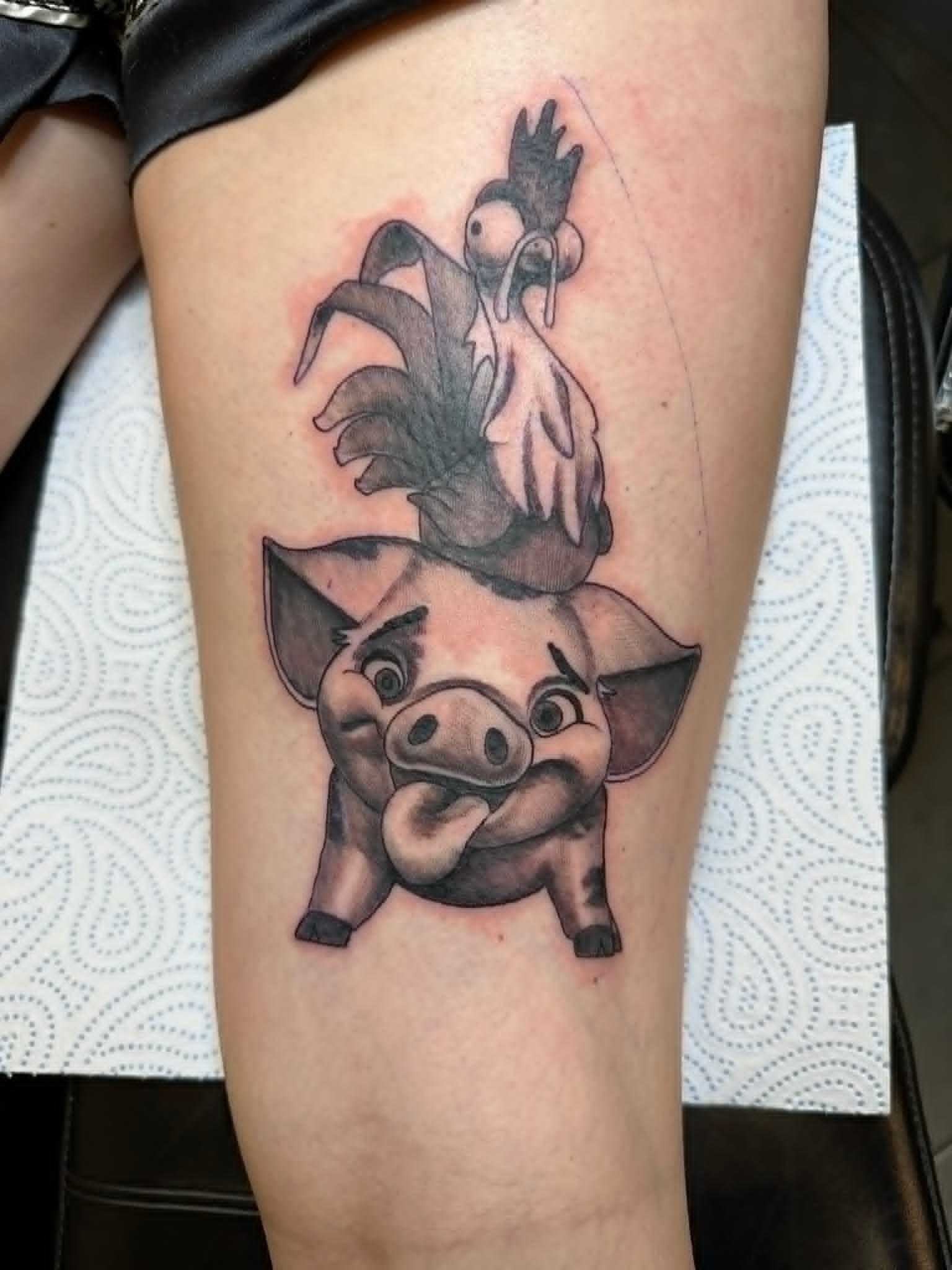 Custom Disney Moana Pua the pig and Heihei the rooster tattoo in black and grey on the thigh by John Quinn at Tattoo Zone Newcastle.