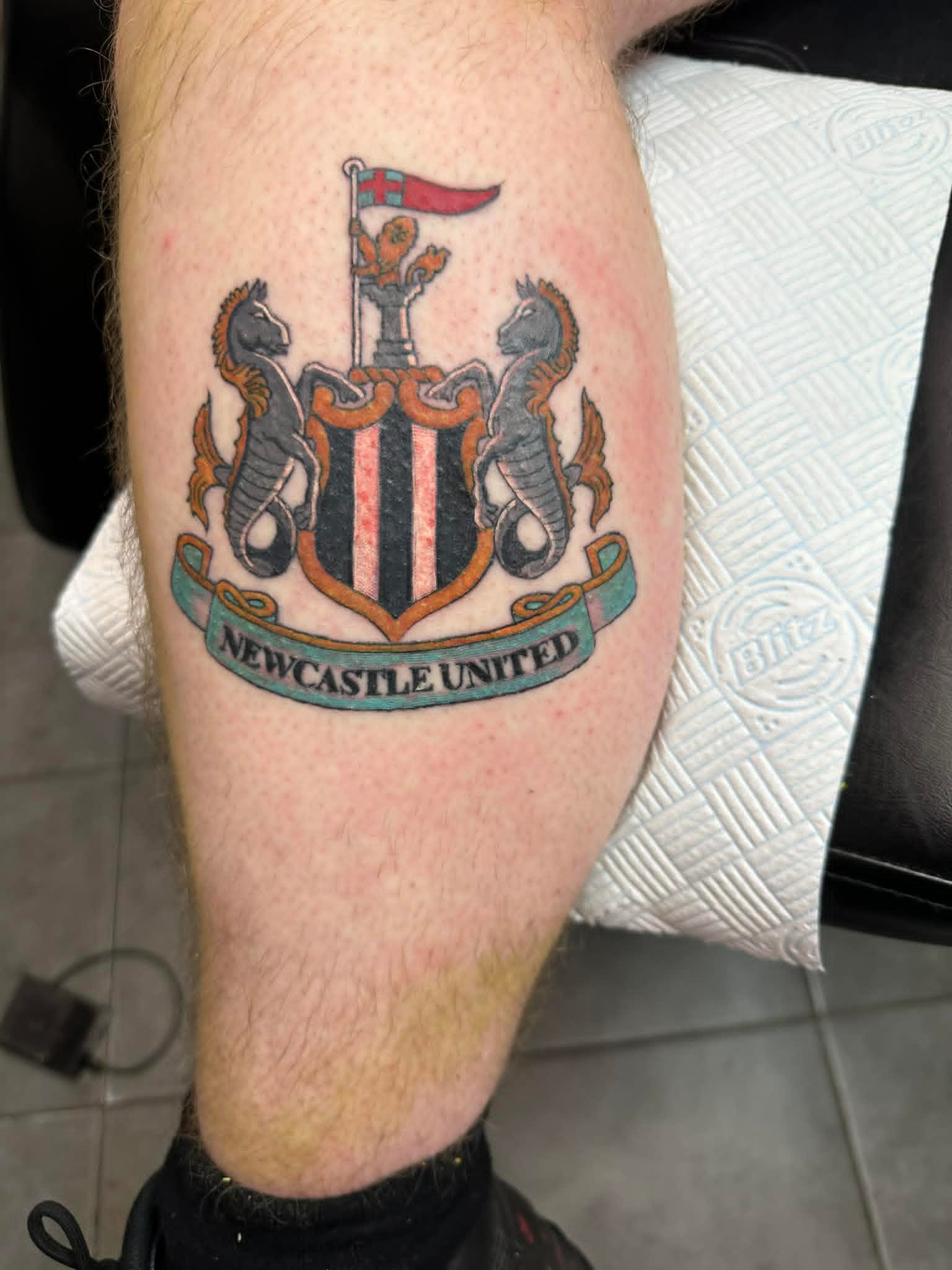 Newcastle United crest with seahorses and shield on calf by John Quinn at Tattoo Zone, tattoos Newcastle.