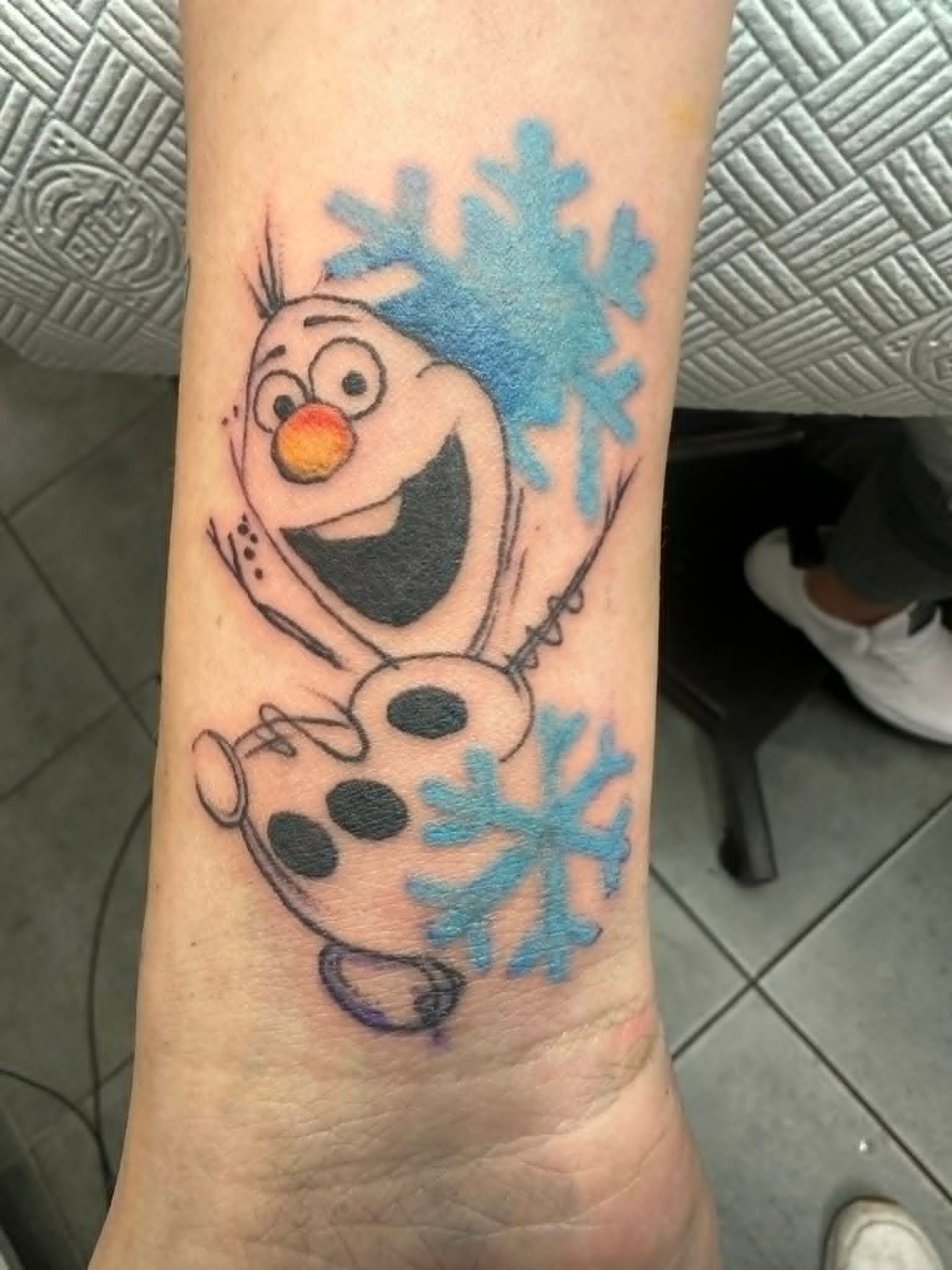 Olaf from Frozen with snowflakes custom tattoo on forearm by John Quinn at Tattoo Zone, tattoos Newcastle.