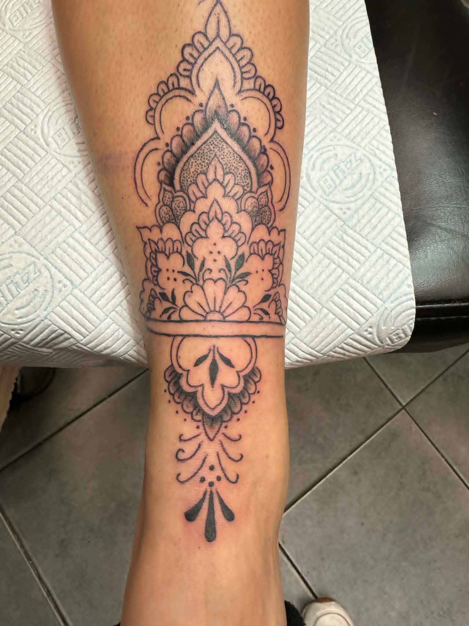 Fine line ornamental mandala band on shin by John Quinn at Tattoo Zone, tattoos Newcastle.