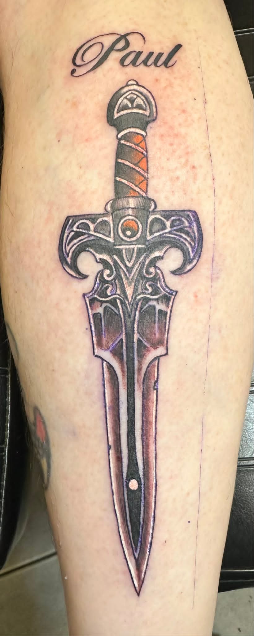 Traditional ornate dagger with Paul name script on calf by John Quinn at Tattoo Zone, tattoos Newcastle.