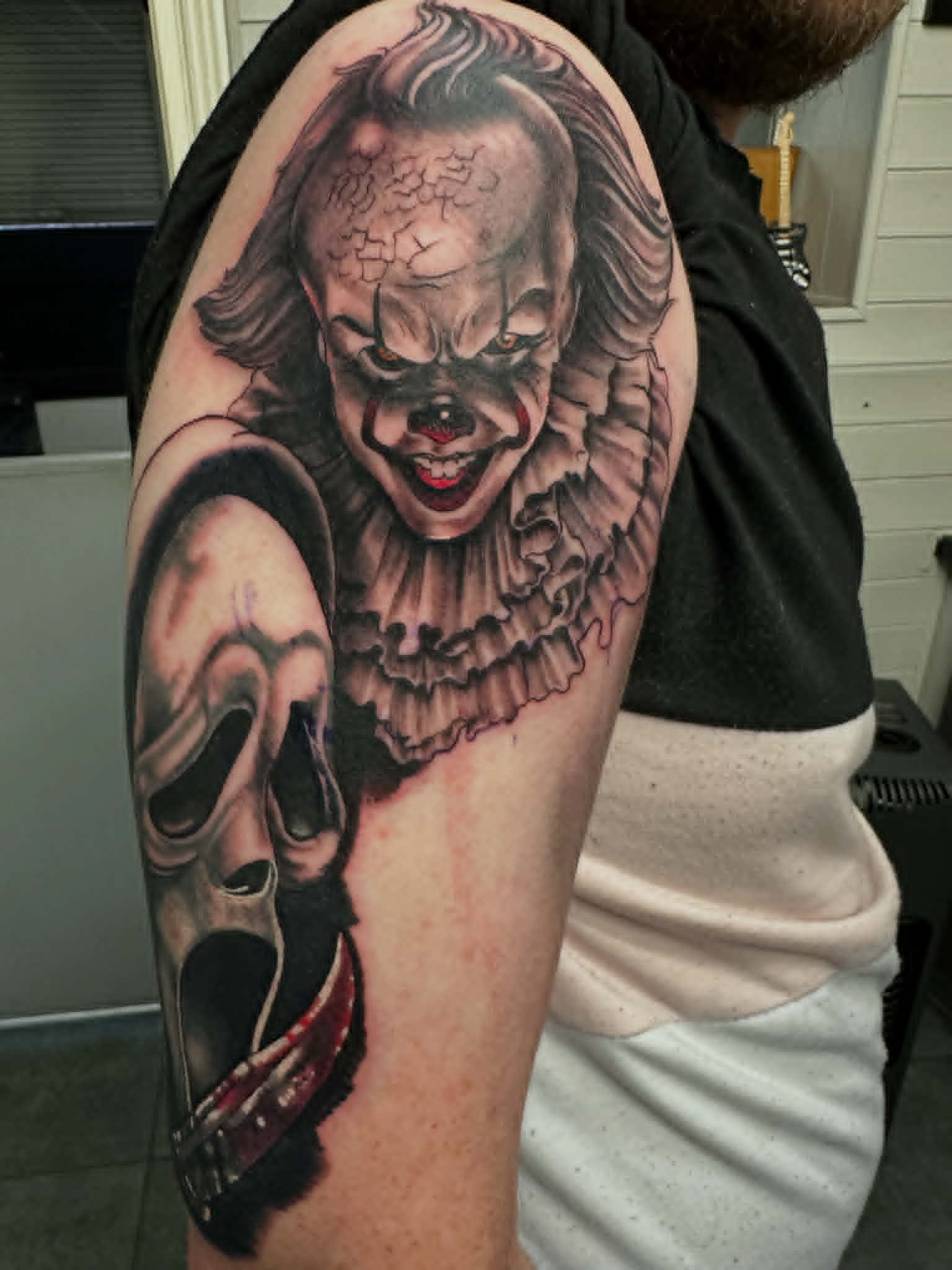 Realism Pennywise and Ghostface horror movie tattoo on the upper arm by John Quinn at Tattoo Zone, tattoos Newcastle.