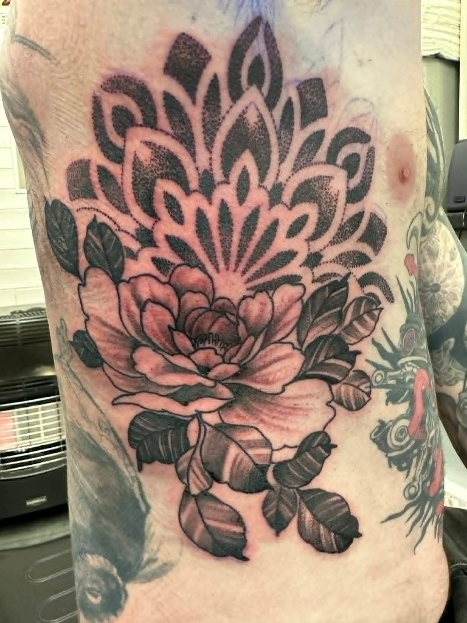 Black and grey peony with dotwork mandala on the ribs by John Quinn at Tattoo Zone, tattoos Newcastle.