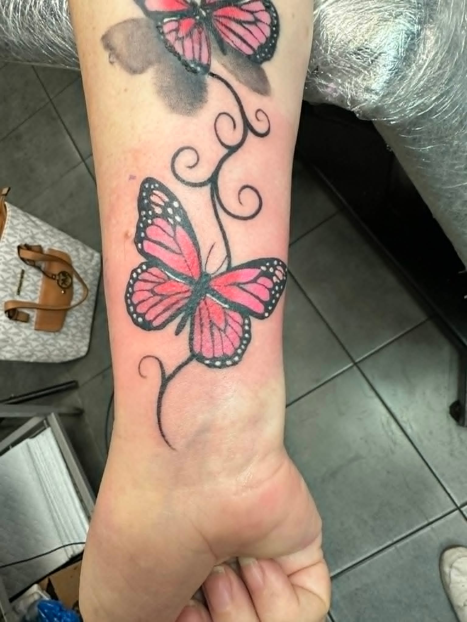 Pink monarch butterflies cover up tattoo on the wrist by John Quinn at Tattoo Zone, tattoos Newcastle.