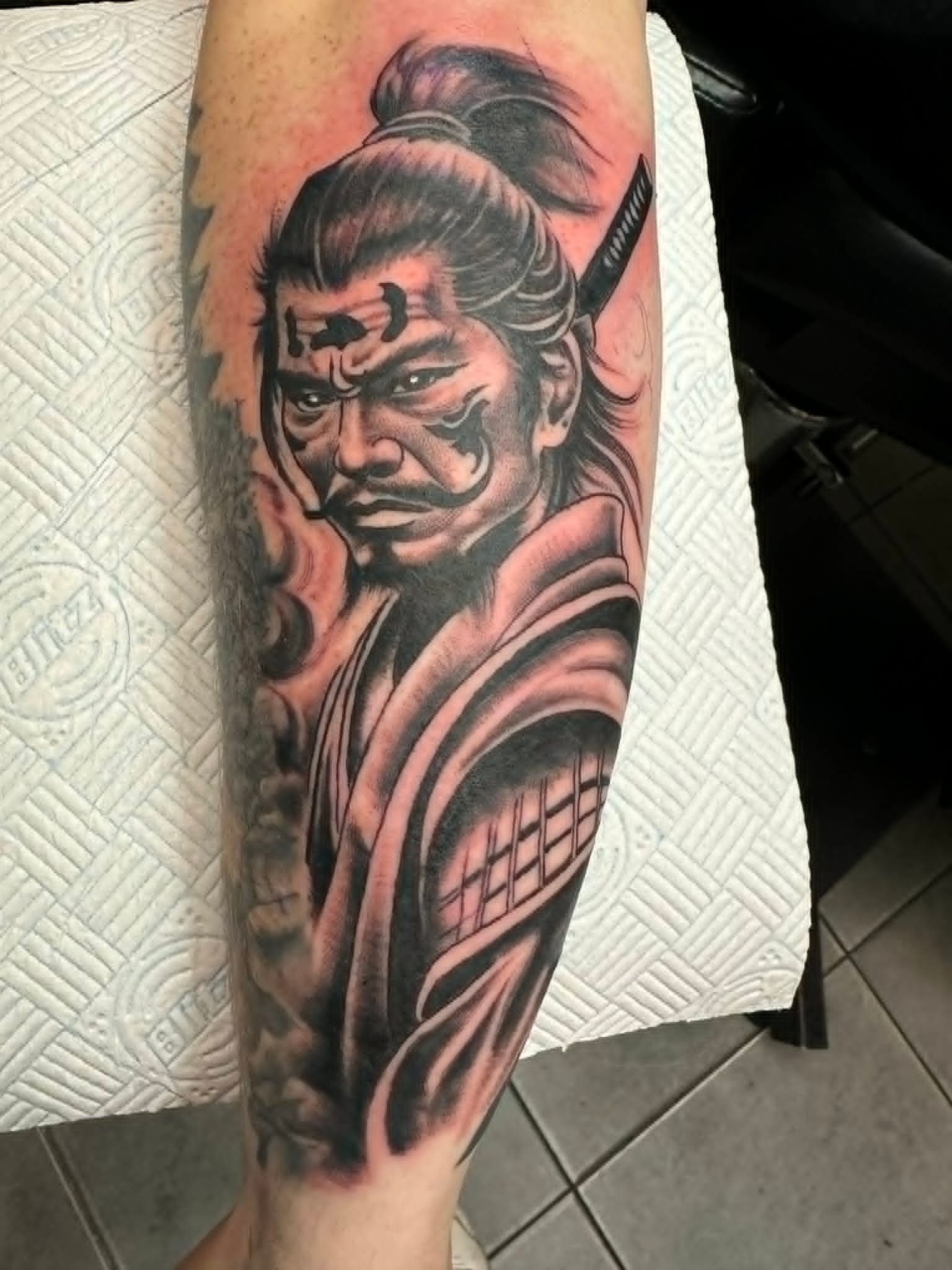 Black and grey samurai warrior portrait with katana on the calf by John Quinn at Tattoo Zone, tattoos Newcastle.