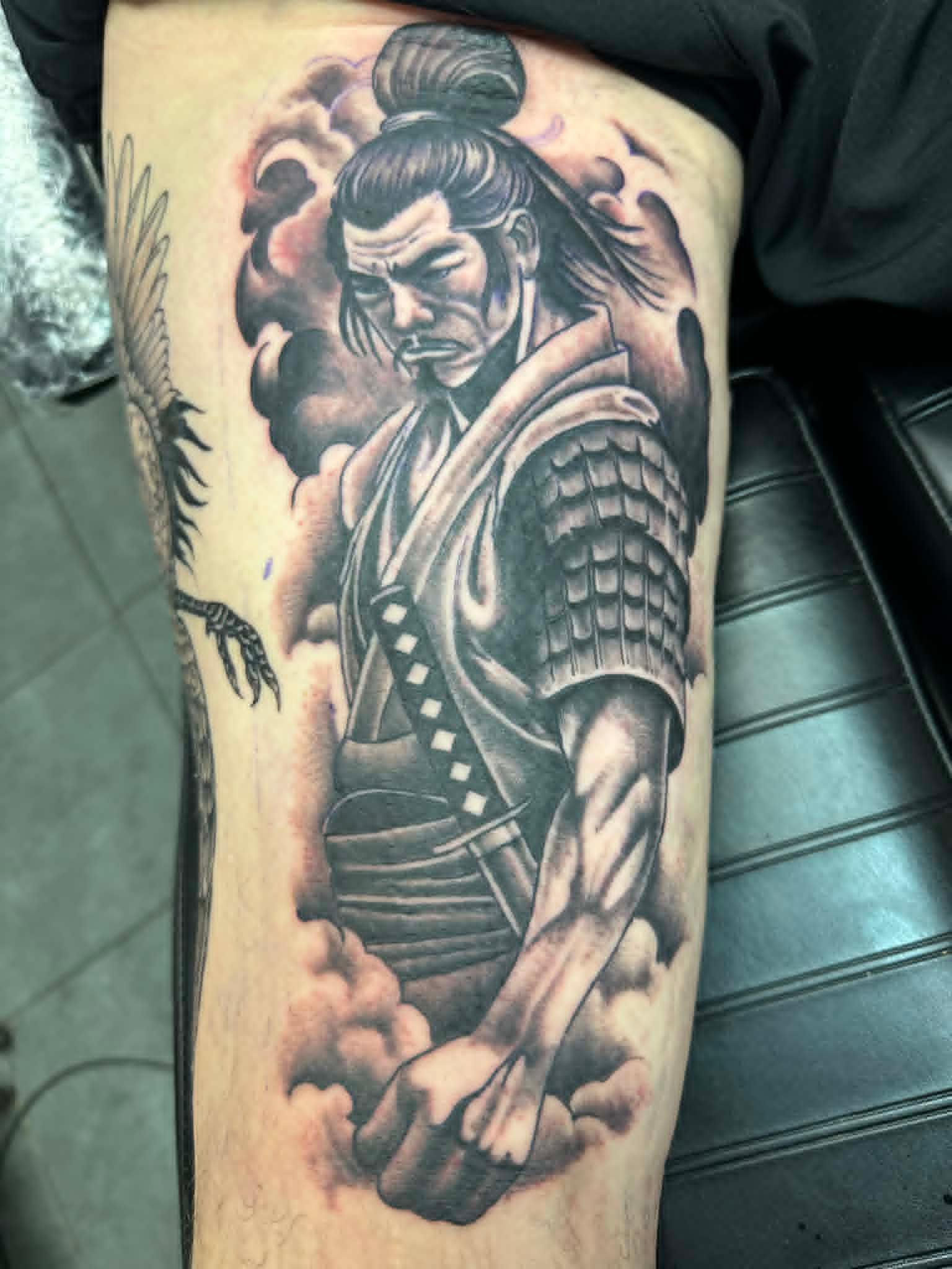 Black and grey samurai warrior with clouds tattoo on the thigh by John Quinn at Tattoo Zone Newcastle.