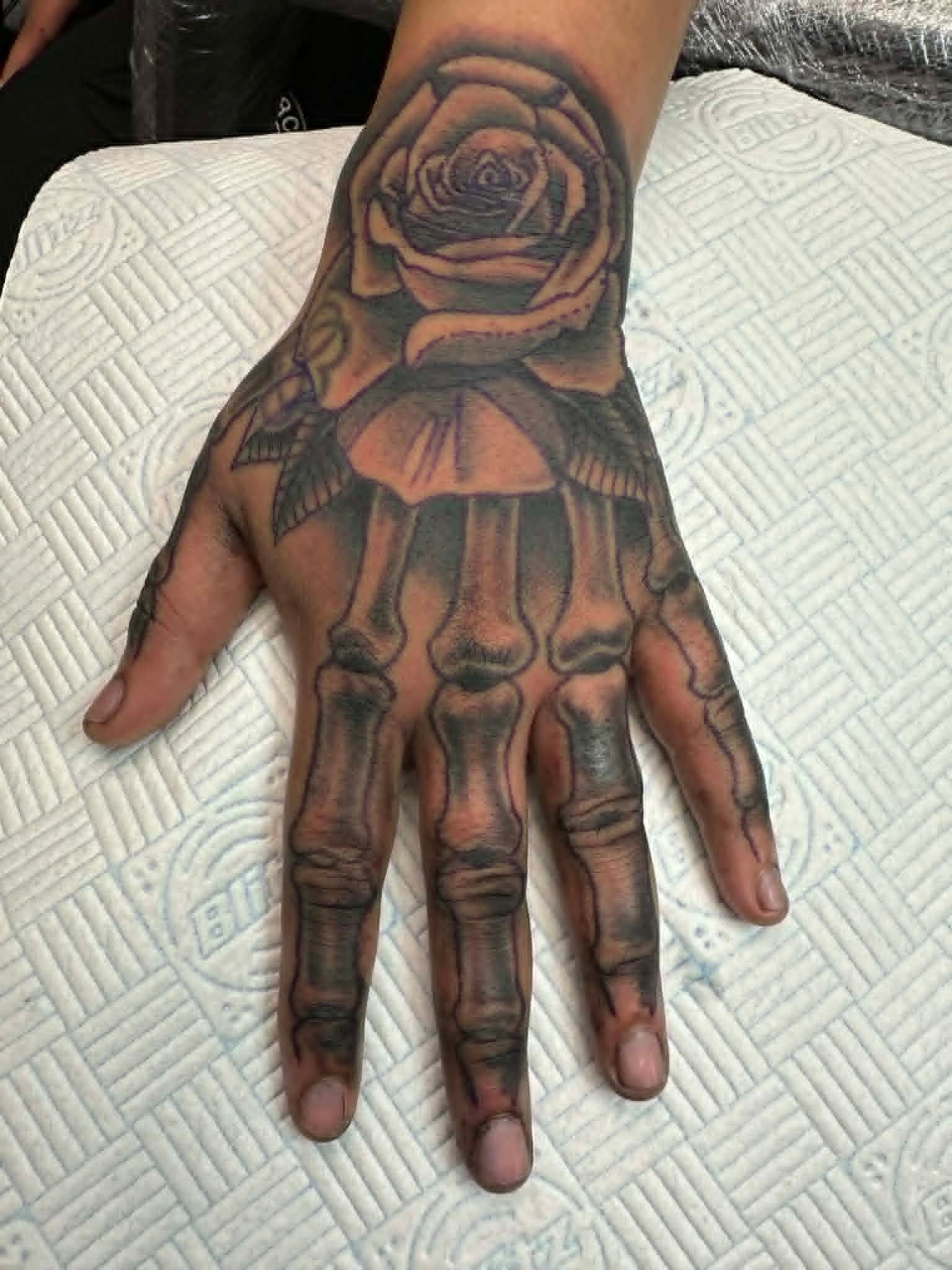 Black and grey skeleton hand with rose on hand by John Quinn at Tattoo Zone, tattoos Newcastle.