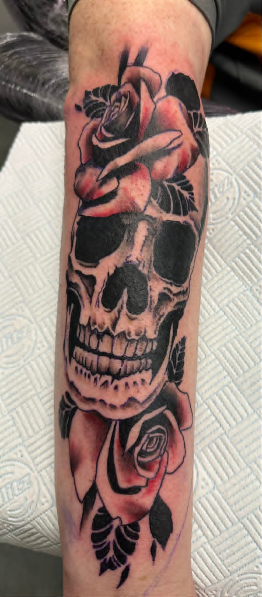Traditional skull with roses on forearm by John Quinn at Tattoo Zone, tattoos Newcastle.
