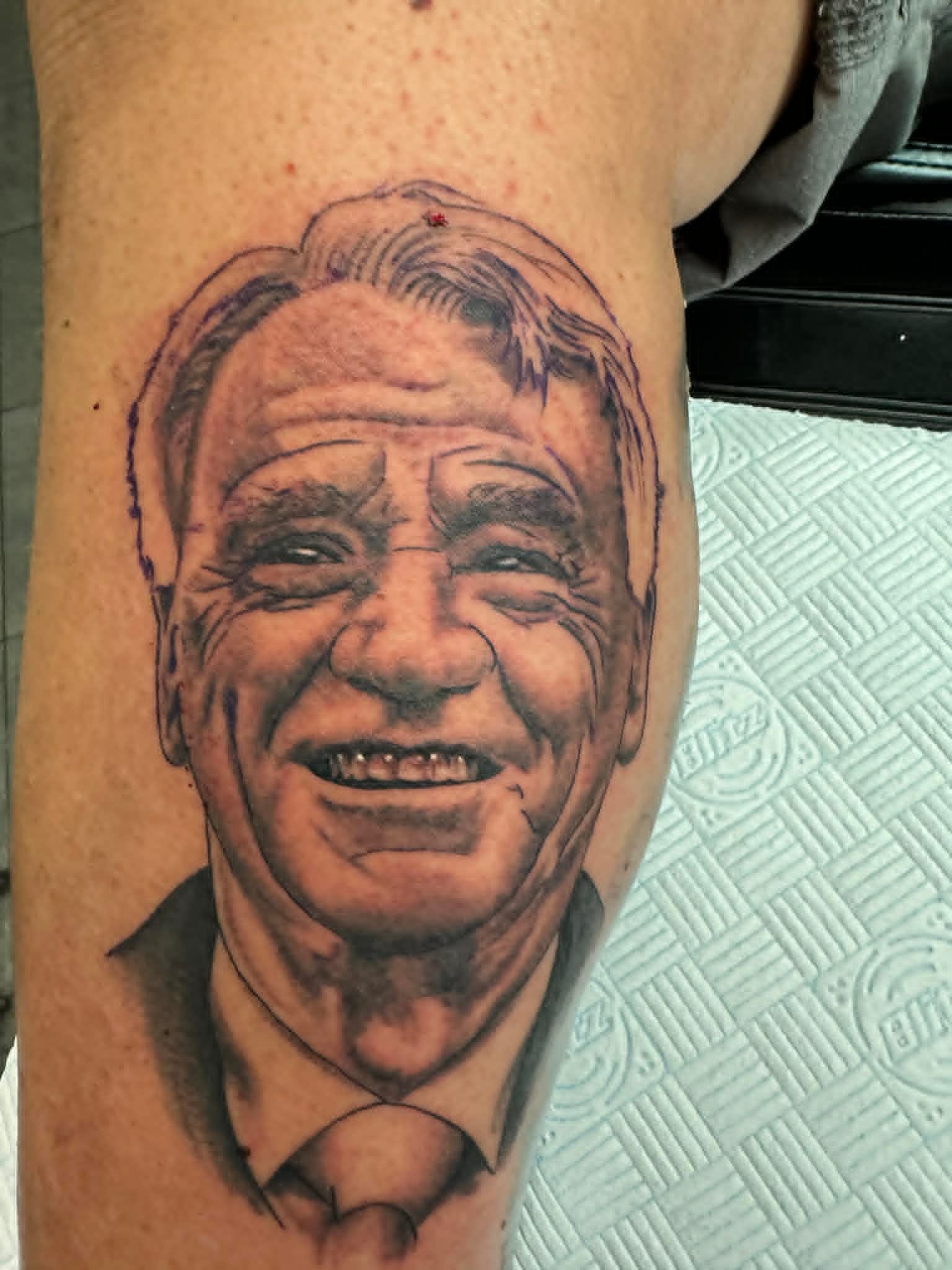 Realistic black and grey smiling man memorial portrait by John Quinn at Tattoo Zone, tattoos Newcastle.