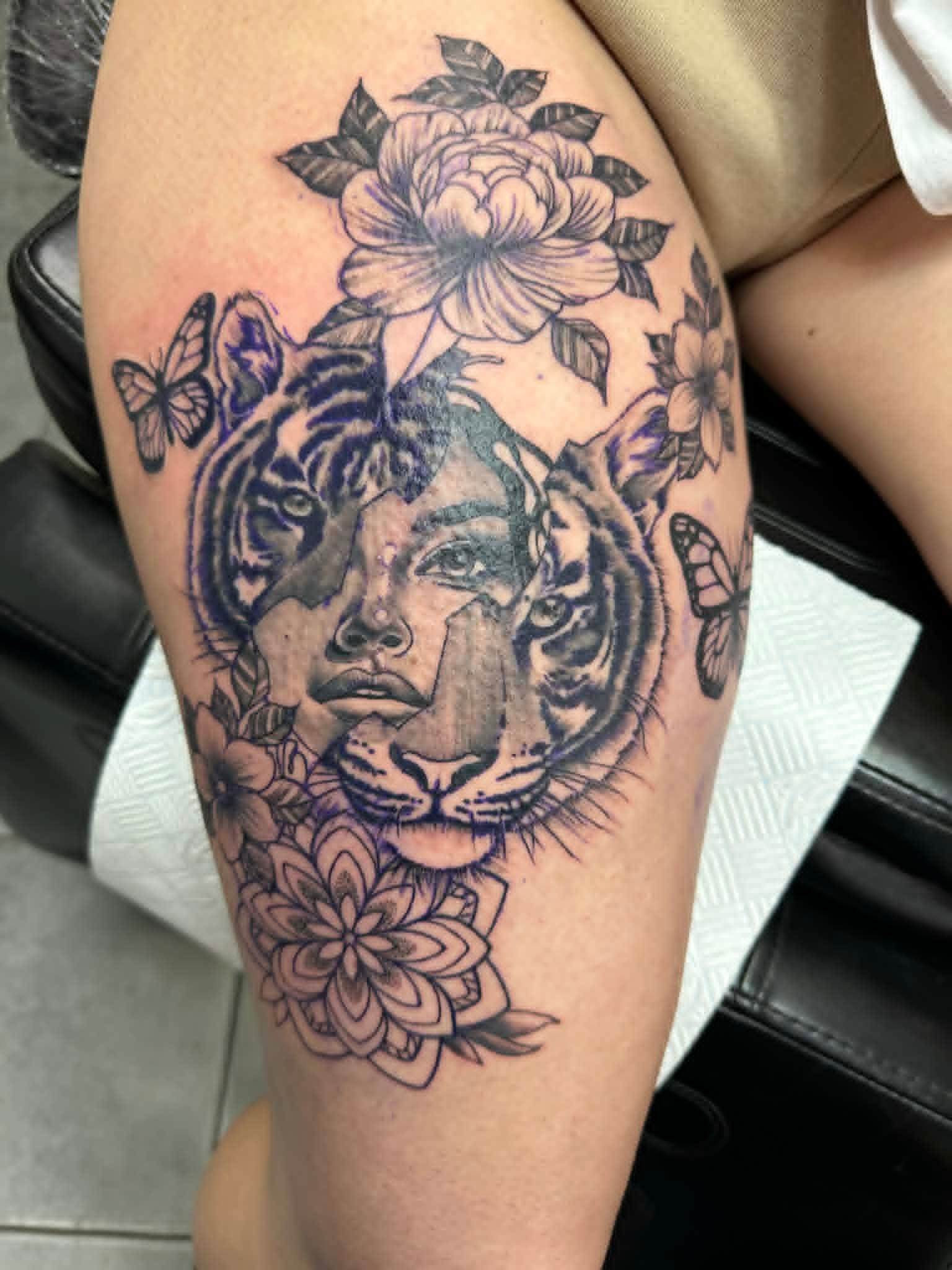 Split tiger and woman face portrait with peony, mandala and butterflies in black and grey by John Quinn at Tattoo Zone Newcastle.