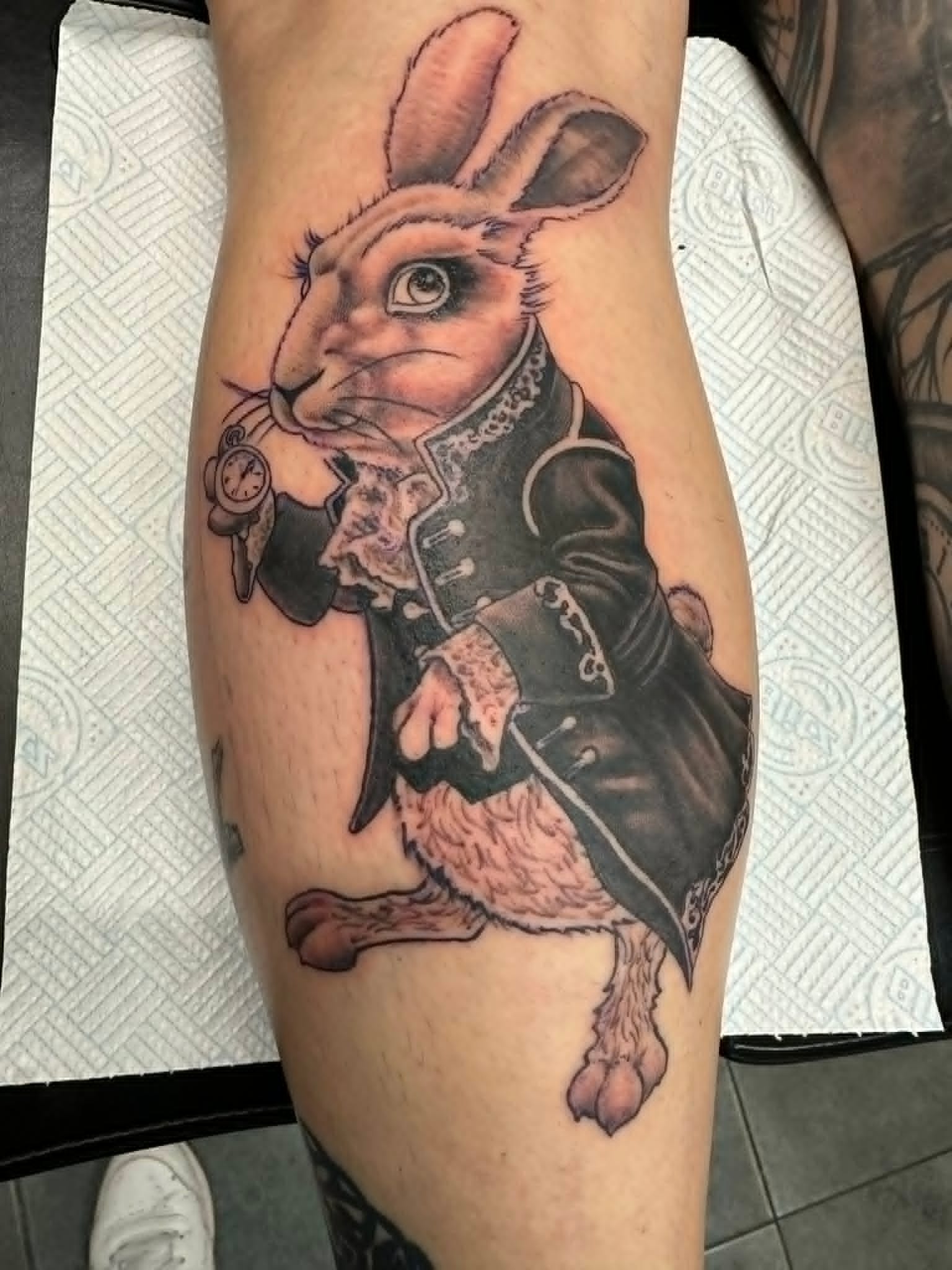 Black and grey realism Alice in Wonderland white rabbit calf tattoo by John Quinn at Tattoo Zone, tattoos Newcastle.