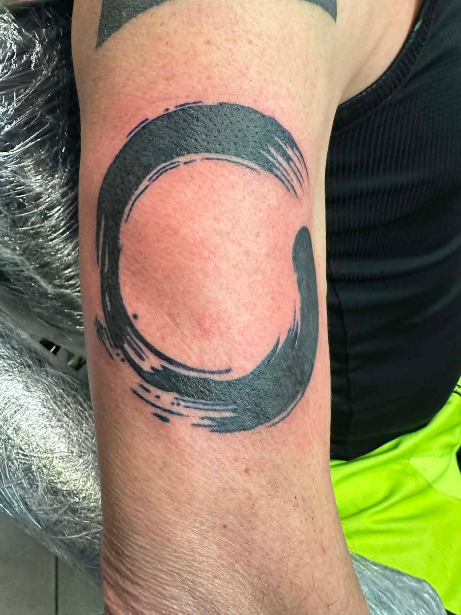 Custom Zen enso brushstroke circle elbow tattoo by John Quinn at Tattoo Zone Newcastle.