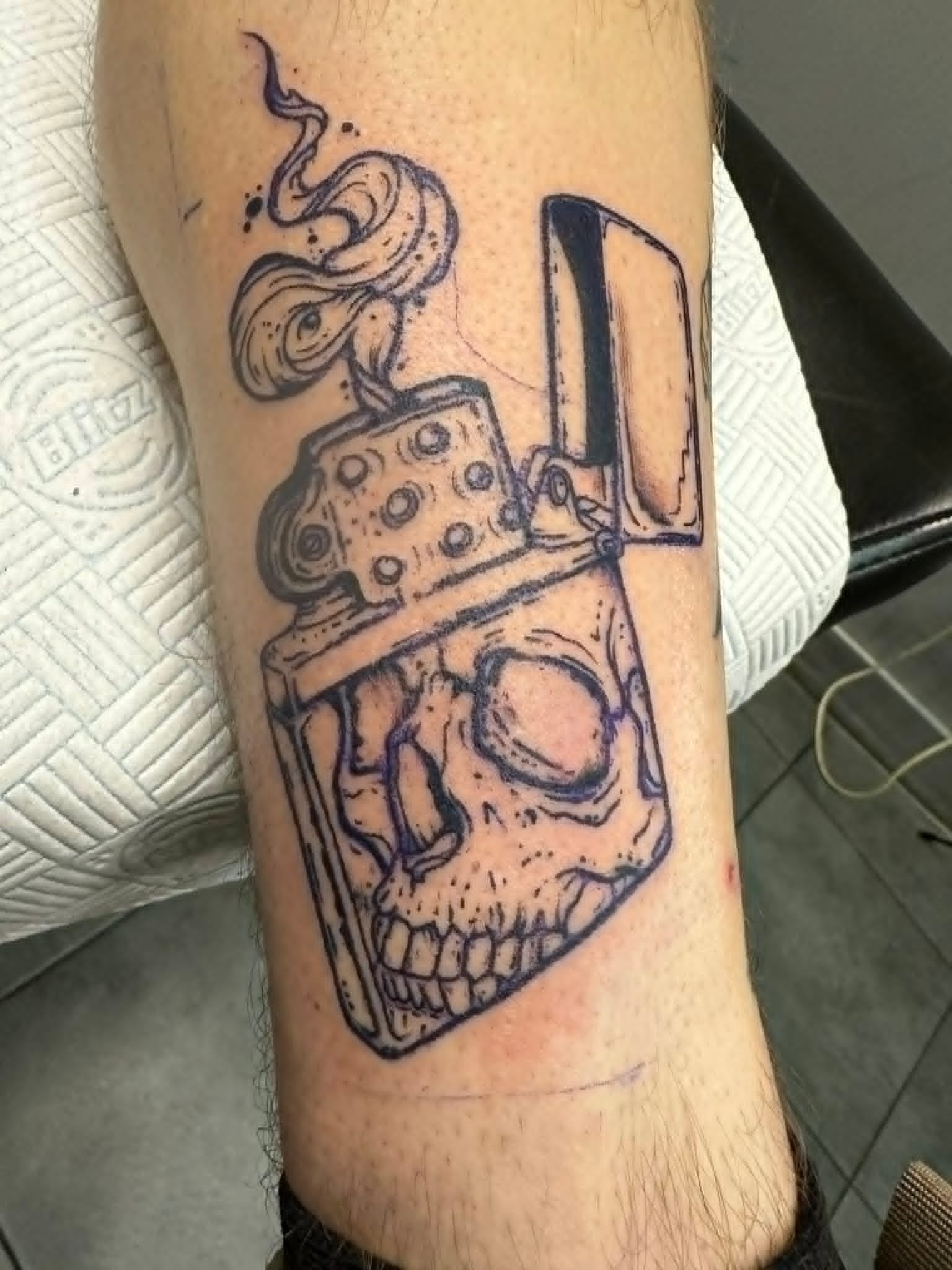 Custom illustrative Zippo lighter with skull tattoo on the arm by John Quinn at Tattoo Zone, tattoos Newcastle.