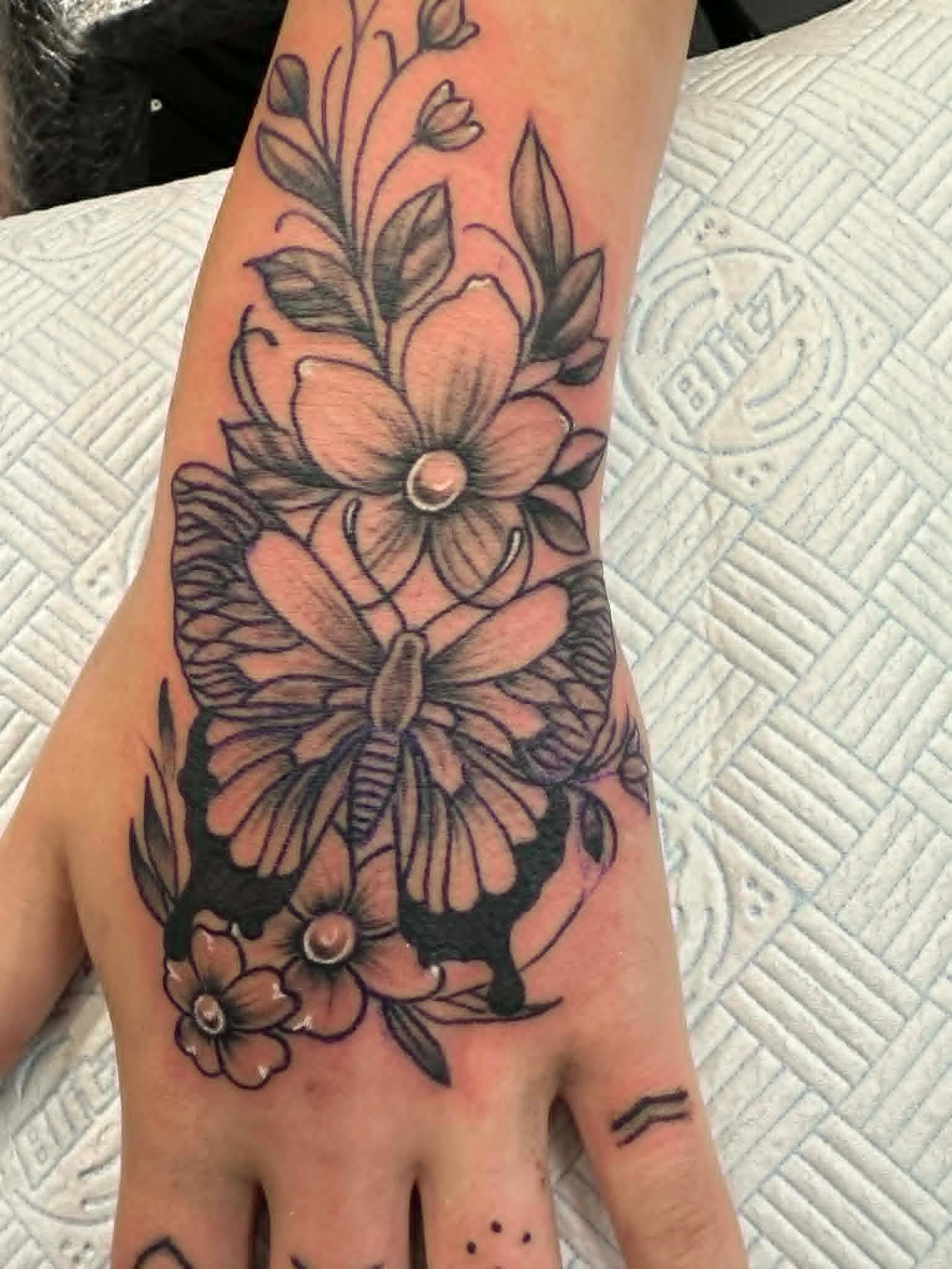 Fine line floral bouquet on hand by John Quinn at Tattoo Zone, tattoos Newcastle.