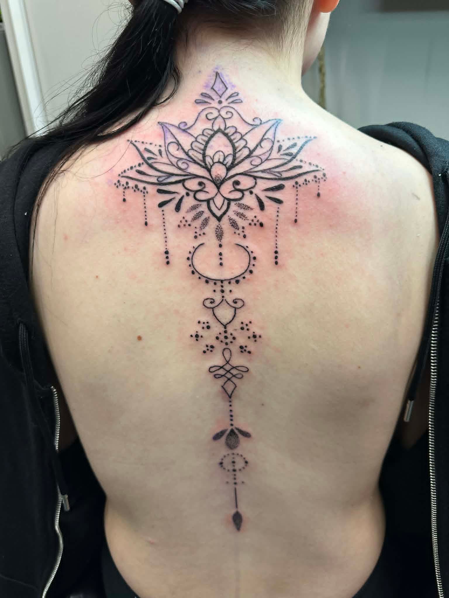 Fine line ornamental lotus mandala along the spine by John Quinn at Tattoo Zone, tattoos Newcastle.